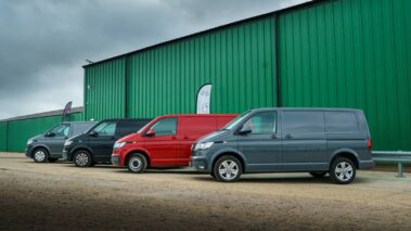 Four VW panel vans lined up next to each other